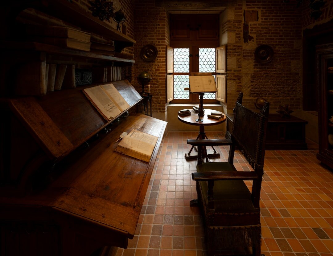 Moody dark study with an old typewriter, notebook and lamp on a wooden desk