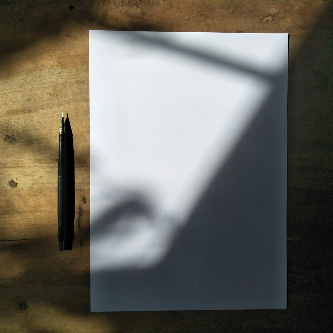 Handwritten manuscript pages with a fountain pen and cup of coffee on a wooden table